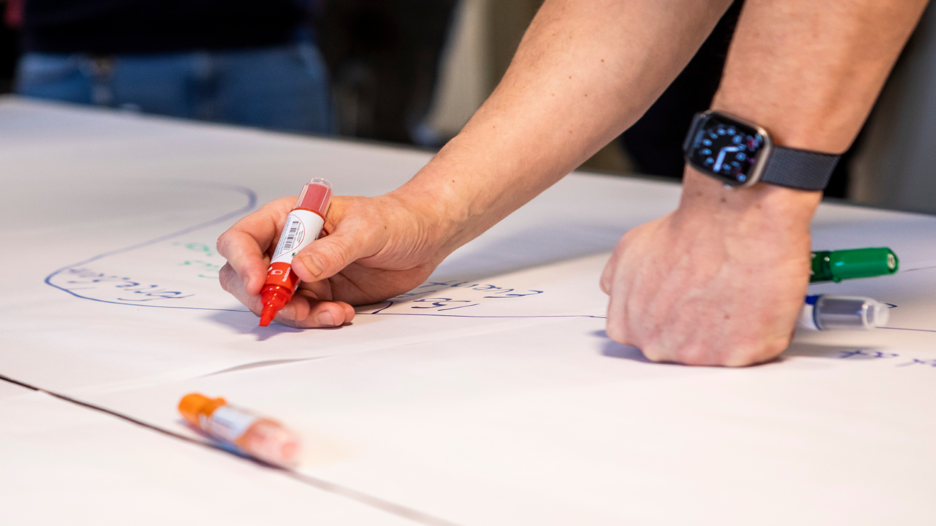 Hands drawing timeline on white paper
