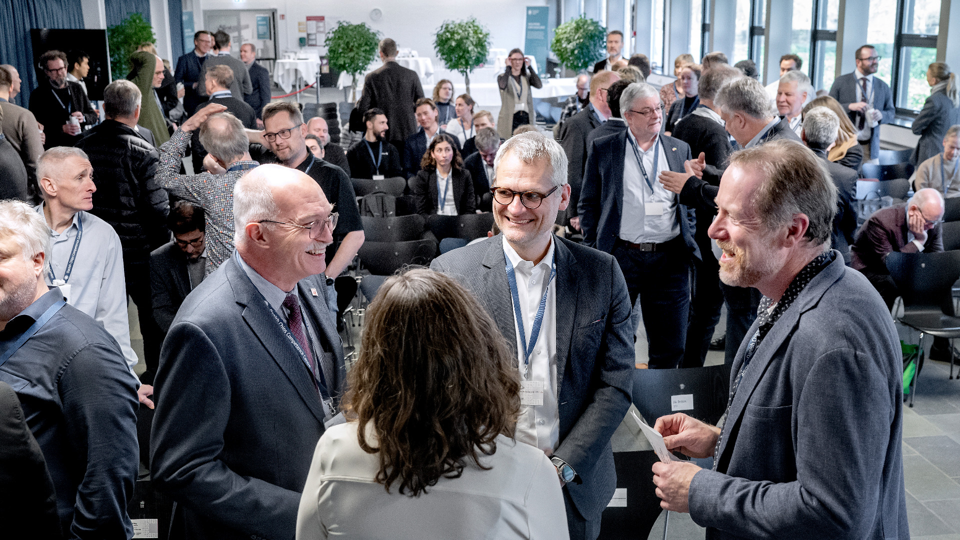 Foto af folk, der står sammen og taler i en cirkel til et netværksevent